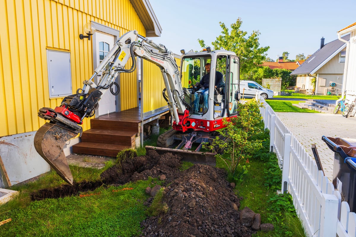 Compact excavator operated by a worker on a construction site