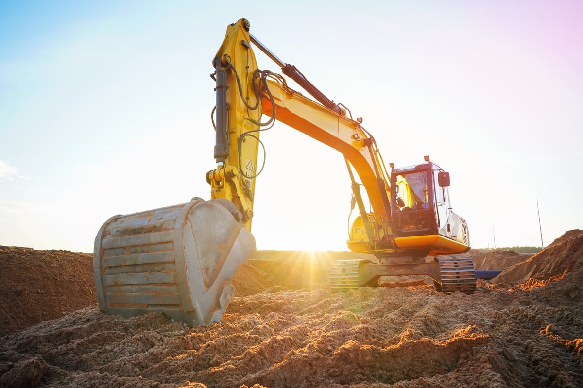 Excavator at a construction site with dirt on its tracks