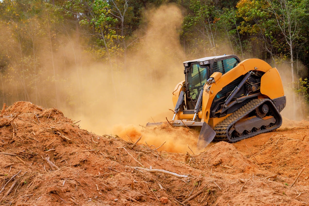 Skid steer loader moving soil at a construction work area